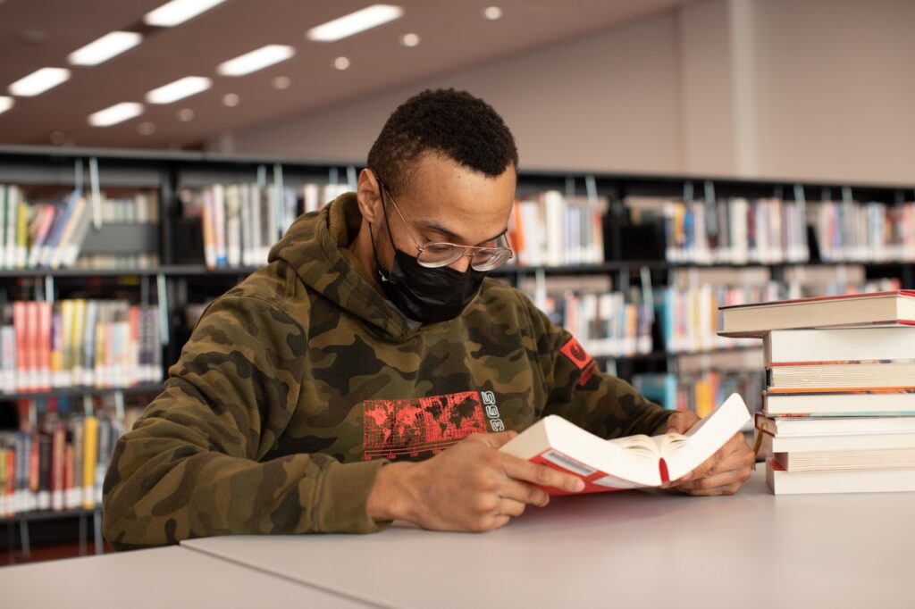 aluno lendo livro em bilbioteca